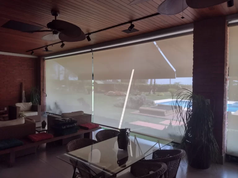 Toldo articulado protegendo varanda no sol e na chuva